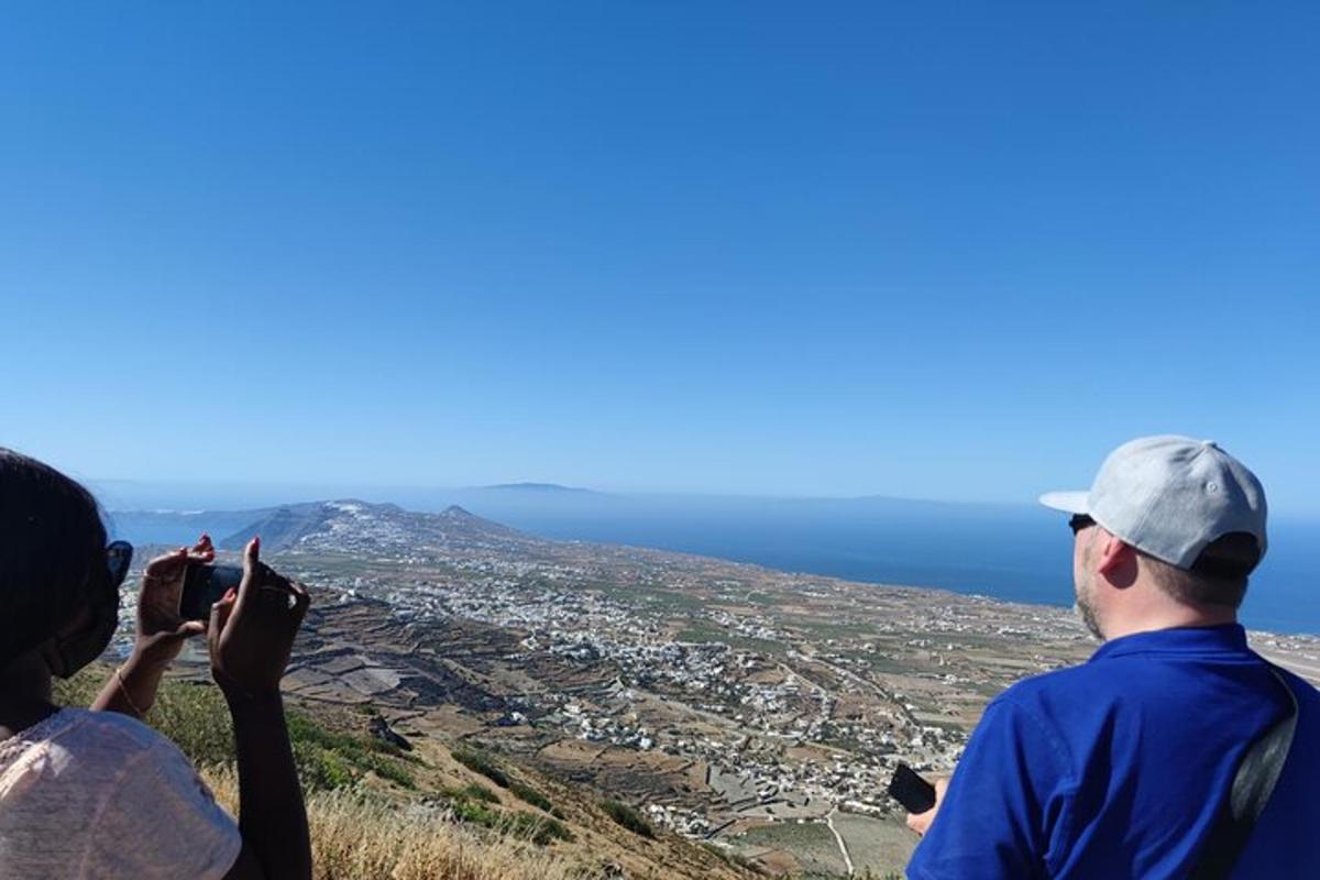 dues persones fent fotos de les vistes des del cim d'una muntanya