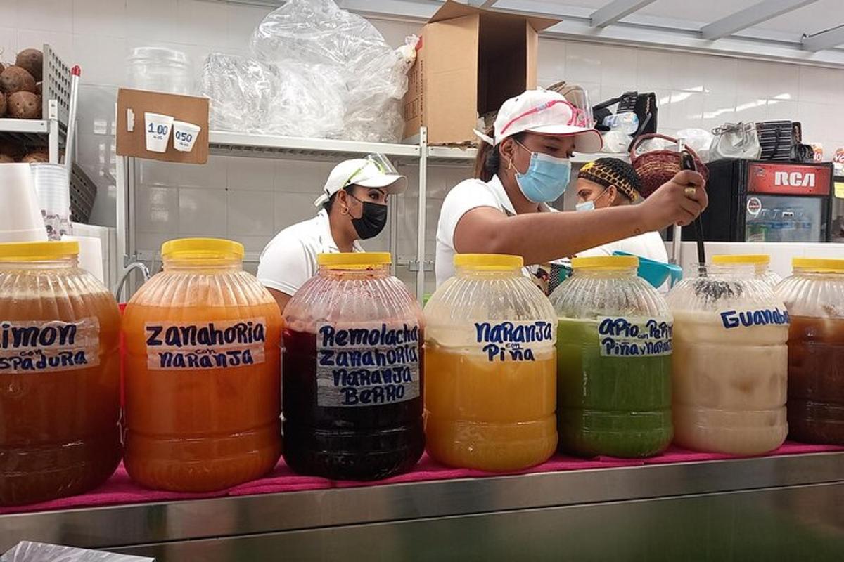 a group of people in a kitchen preparing orange juice