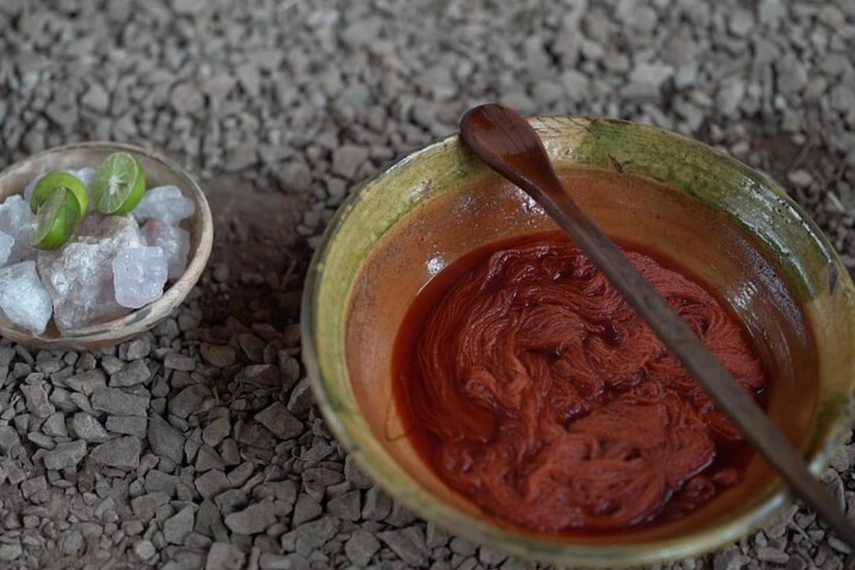 a bowl of sauce with a spoon and a bowl of green onions