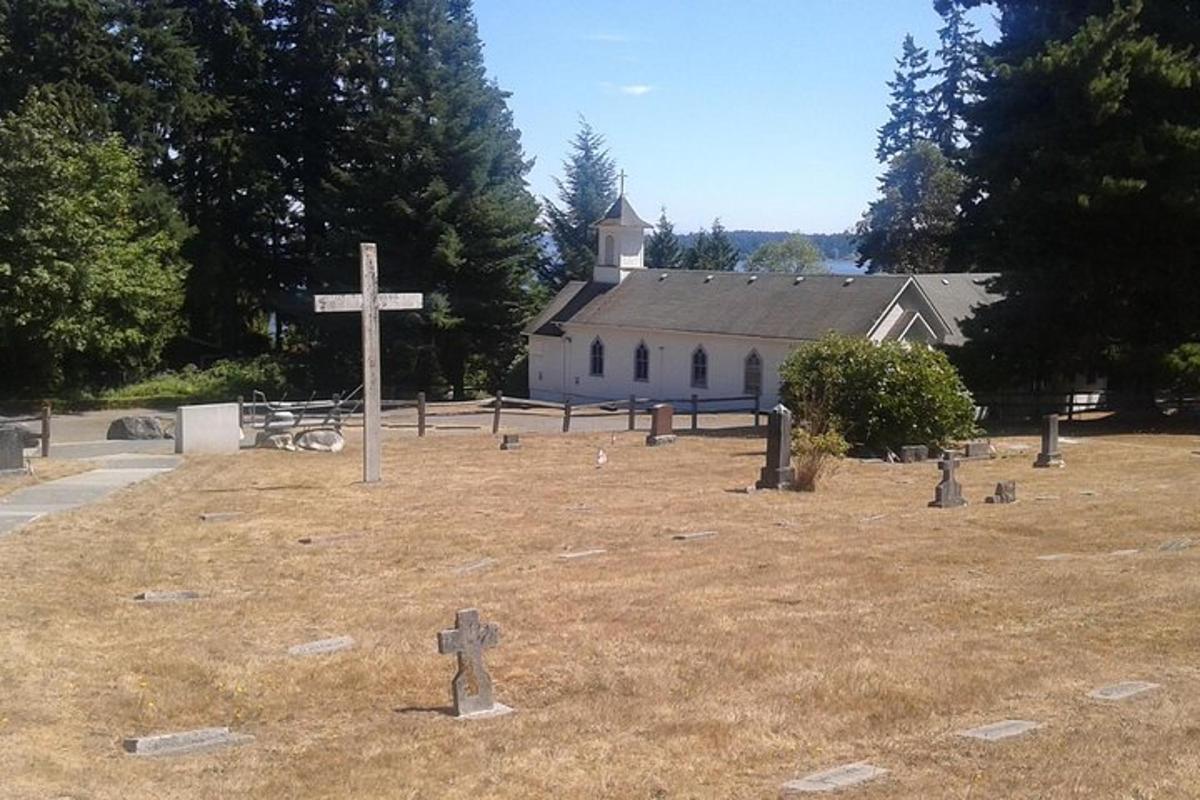 una croce in mezzo a un campo con una chiesa
