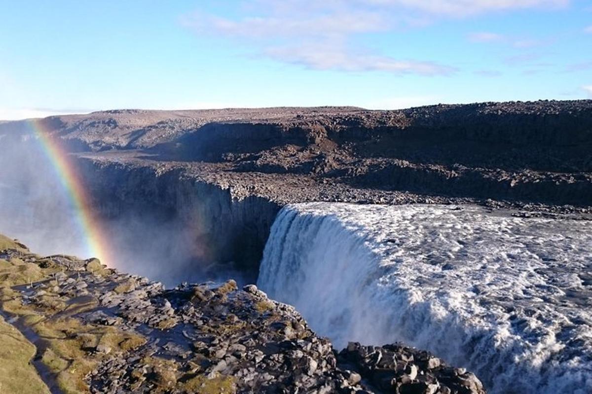 Regnbogi yfir fossi í miðjum gljúfri