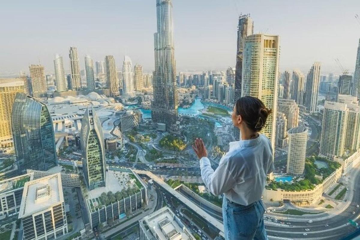 una donna in piedi in cima a un edificio che guarda una città