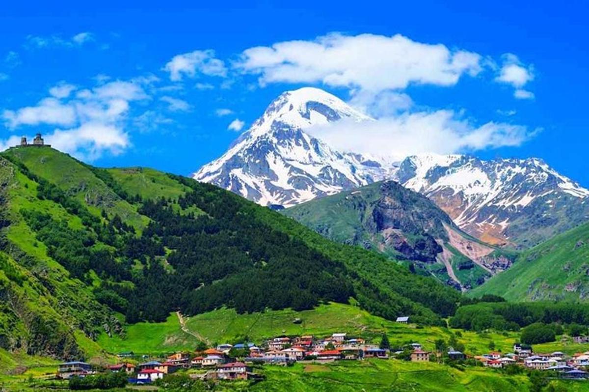 zasnežena gora z vasjo na hribu