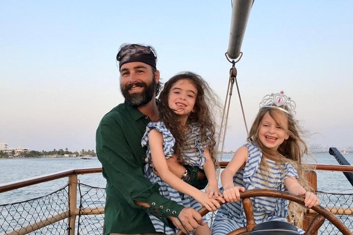 a man and two girls sitting on a boat