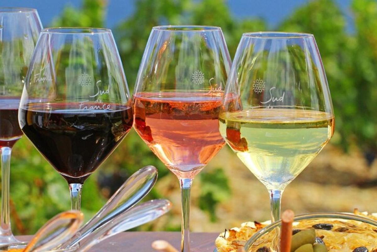 tre bicchieri di vino seduti su un tavolo