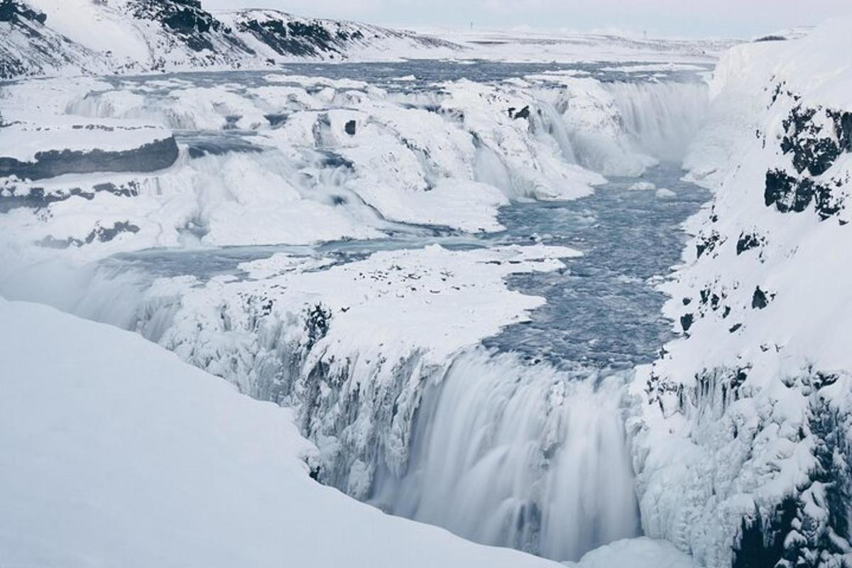 een bevroren waterval met sneeuw aan de zijkanten