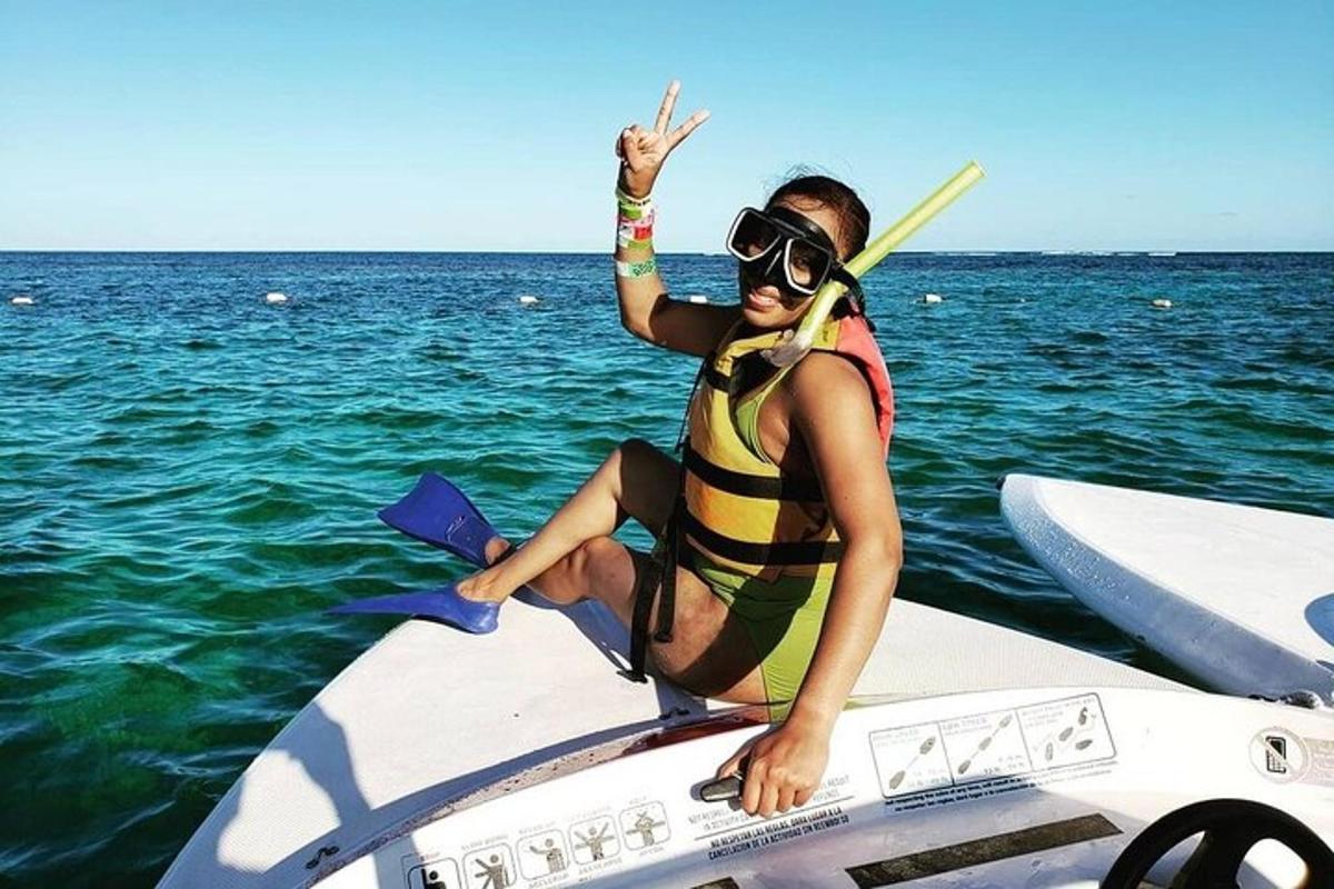a woman in a life vest sitting on a surfboard in the water