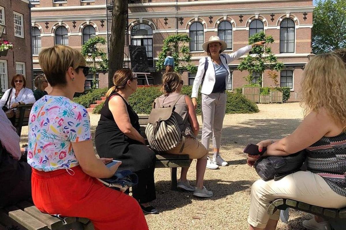 eine Gruppe von Menschen, die auf Bänken vor einem Gebäude sitzen