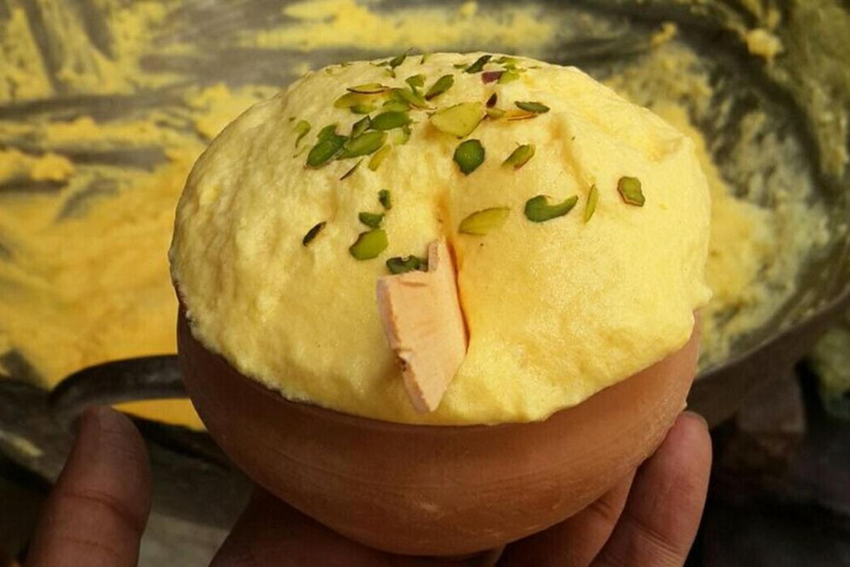 una persona che tiene in mano un panino con cipollotti sopra