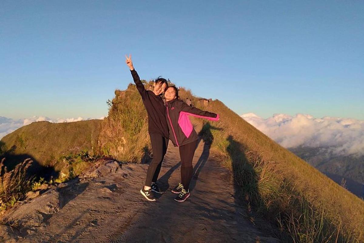 duas pessoas em pé no topo de uma montanha