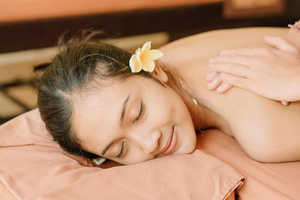 a young girl sleeping on a bed with a flower on her head