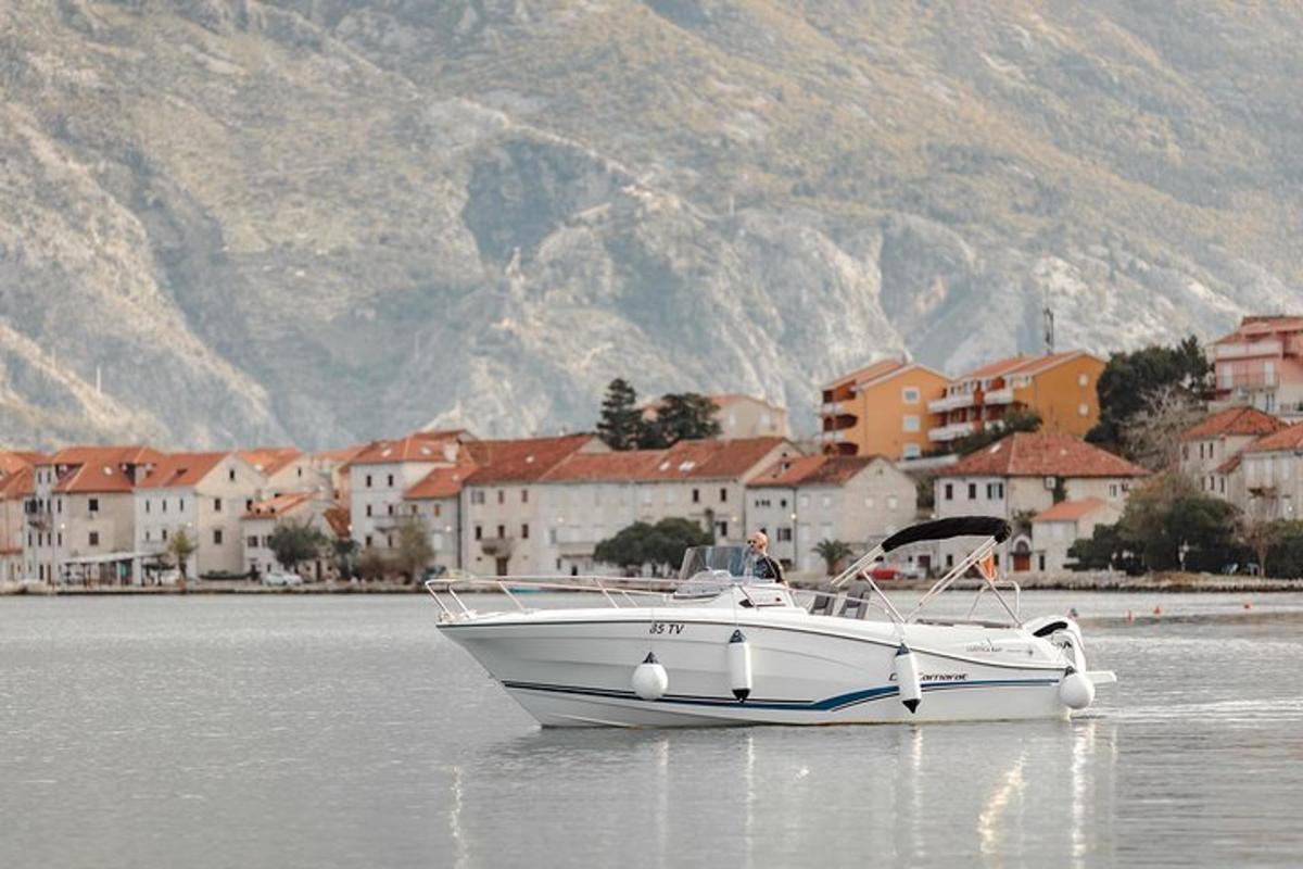 a white boat sitting in the water near a town