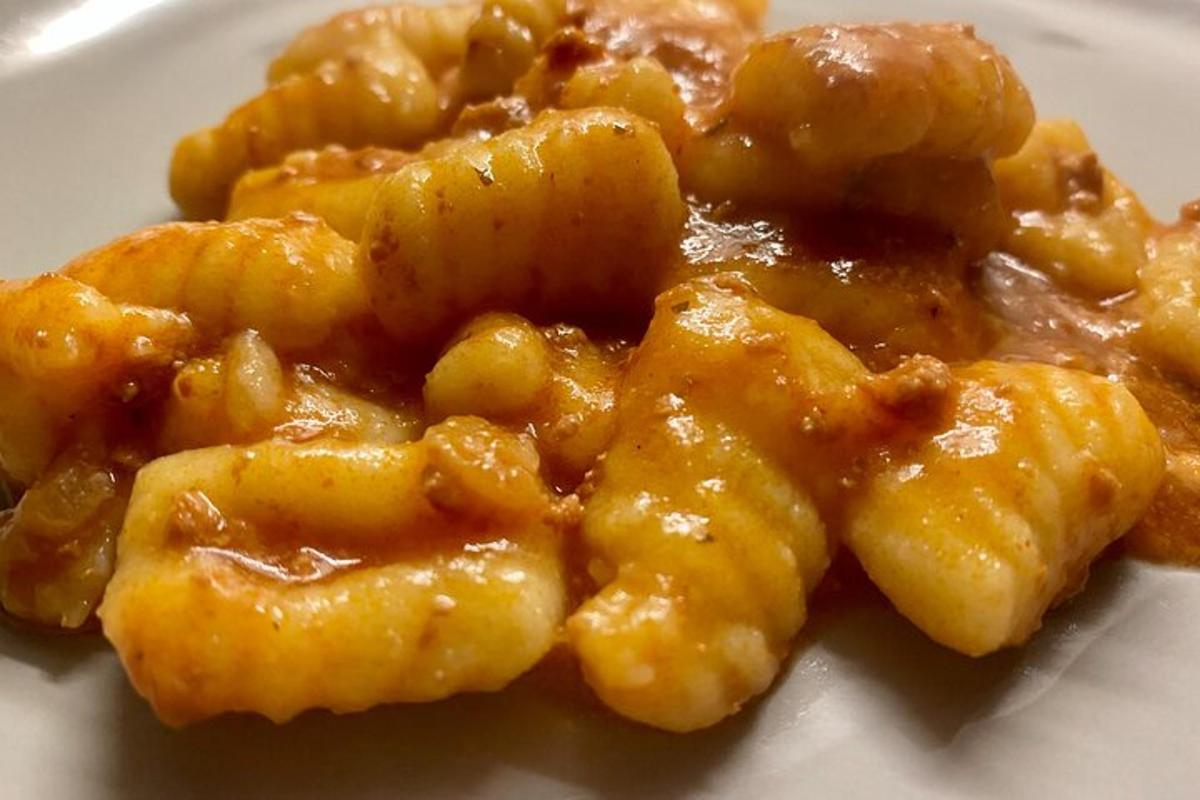 Hrúga af pasta með sósu á hvítum diski