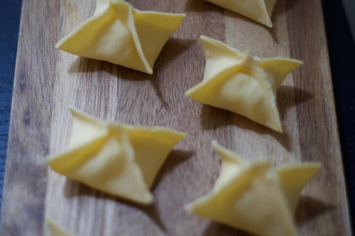 hópur af wonton-brauði á tréskurðarbretti