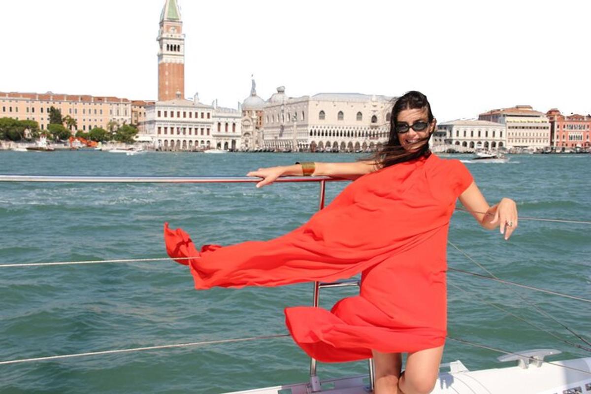 Una mujer con un vestido rojo en un barco en el agua.