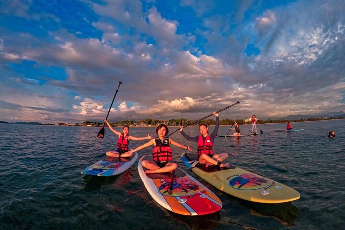 un grup de persones assegudes en taules de paddle surf a l'aigua