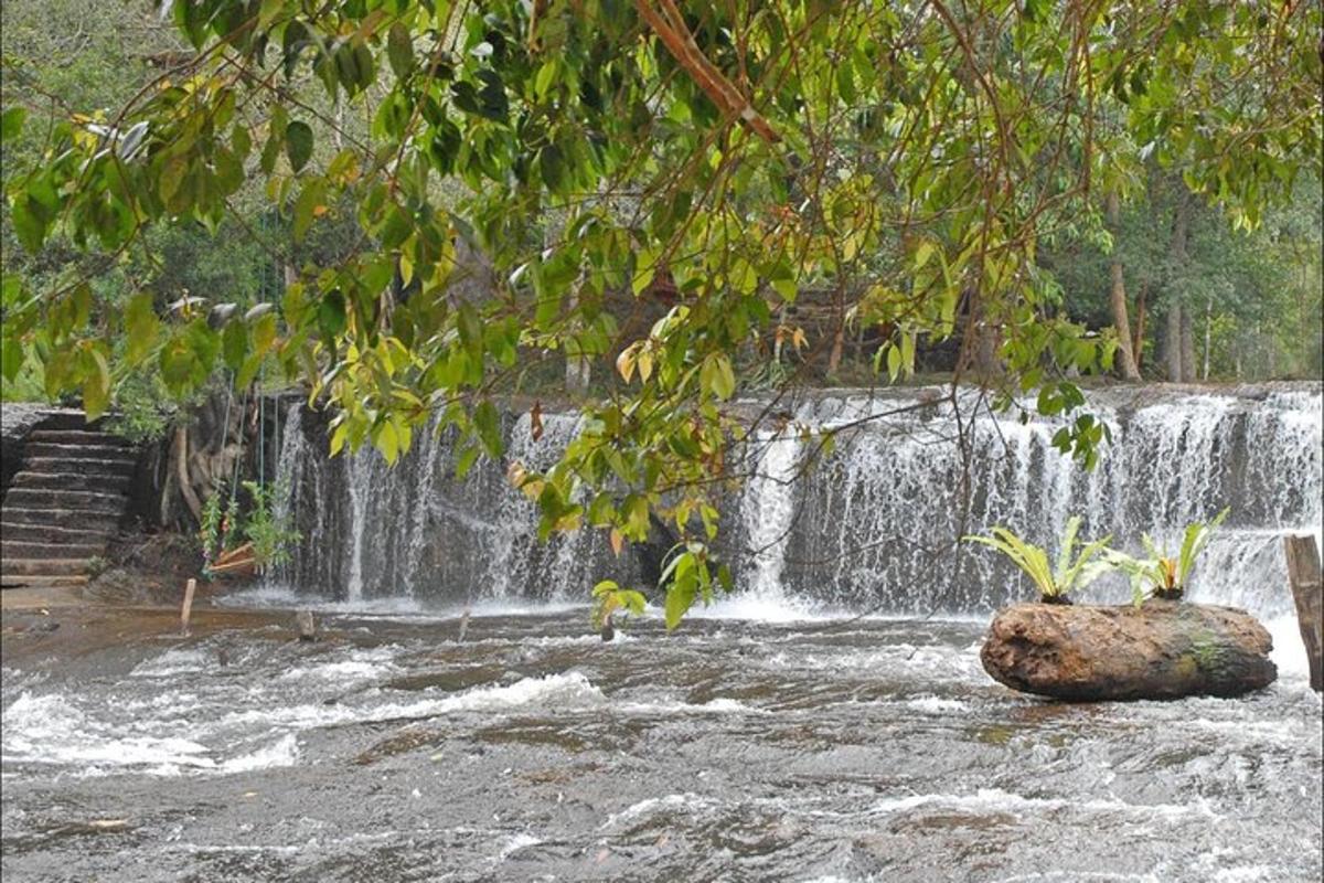 ein Wasserfall mit einem Felsen vor einem Fluss