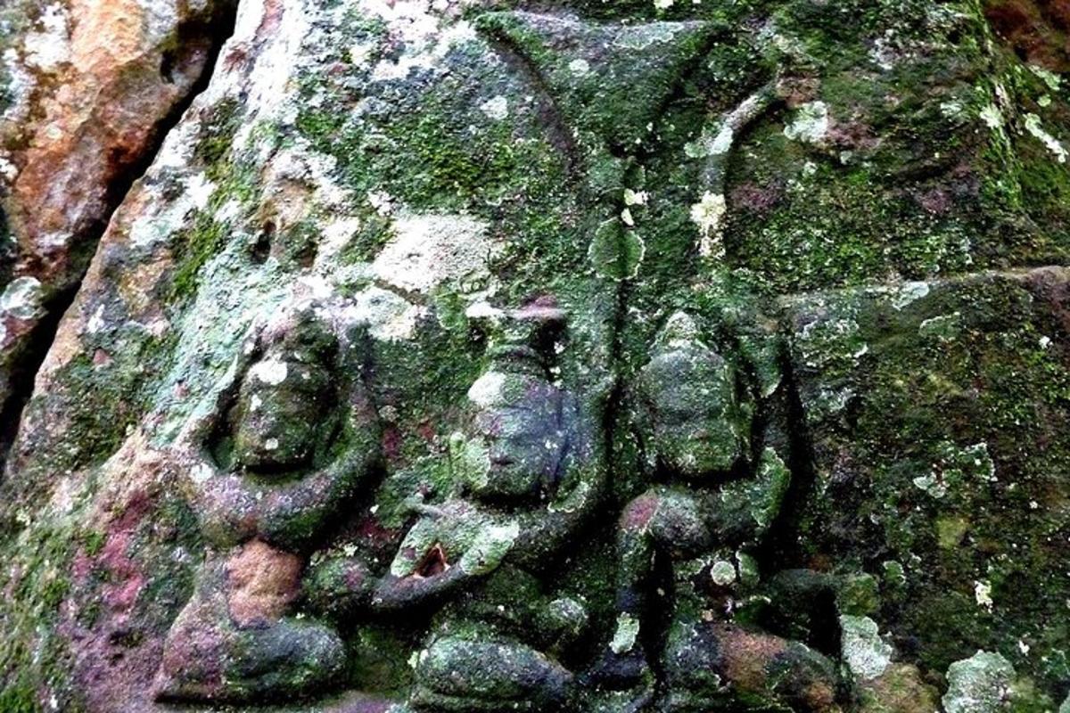 a stone sculpture of three people on a tree