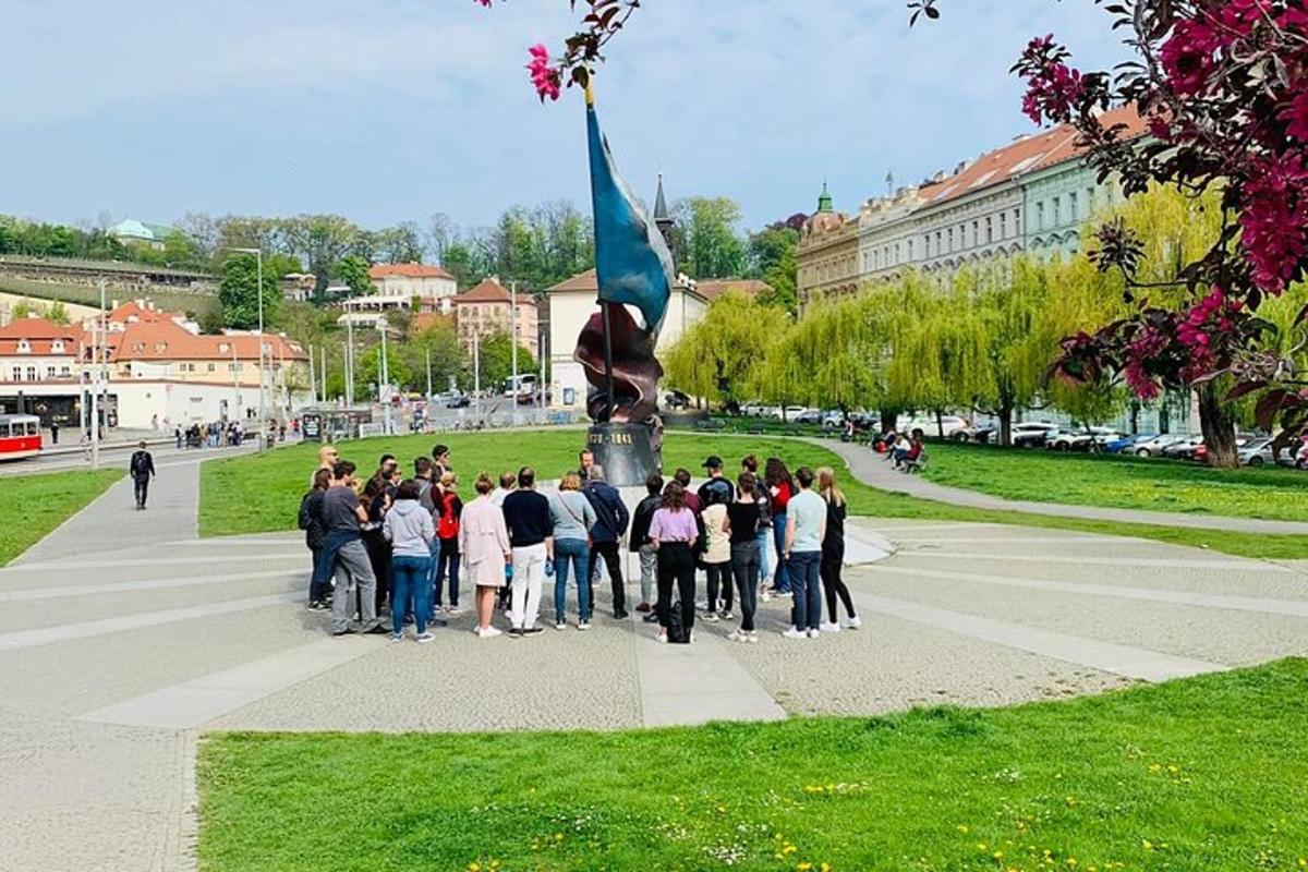egy csoport ember áll egy szobor körül egy parkban
