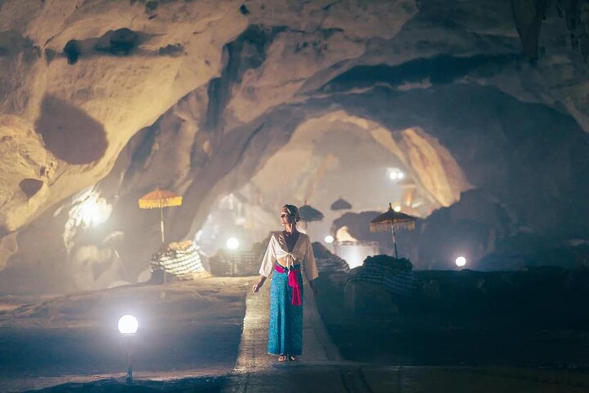 a woman standing in front of a cave