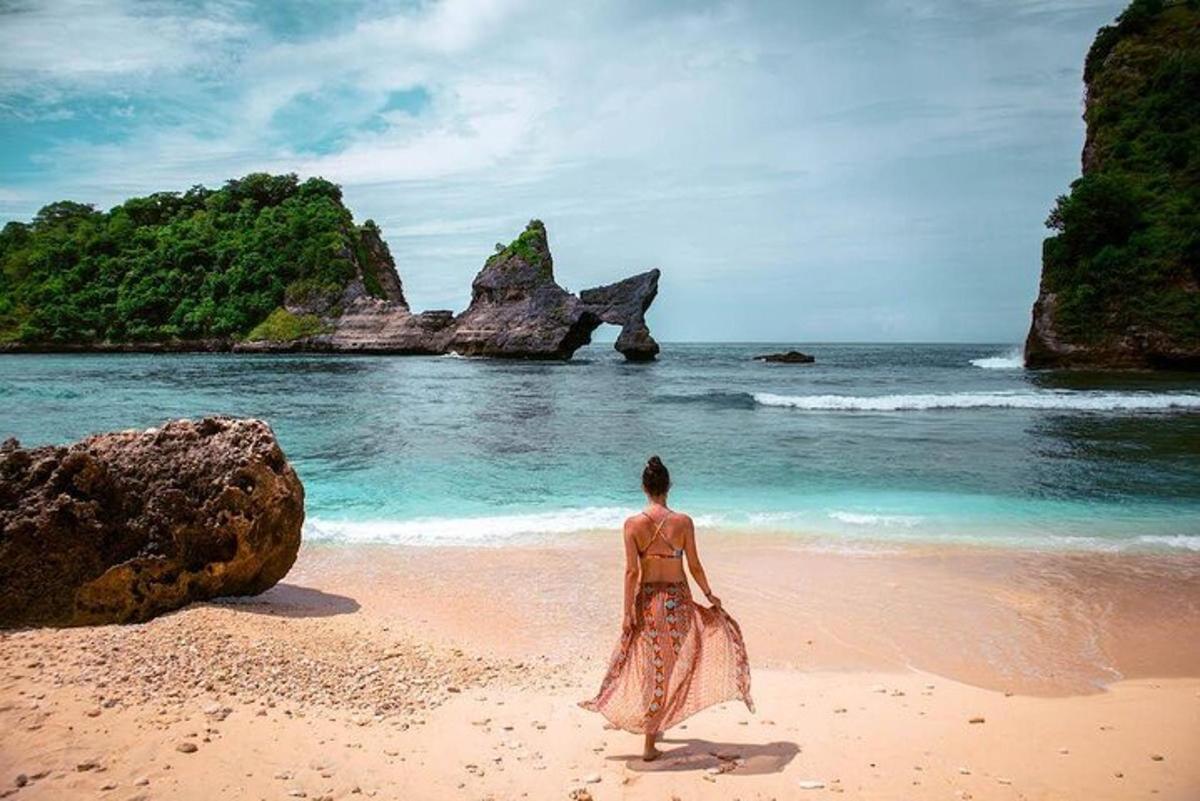 žena stojící na pláži a dívající se na oceán