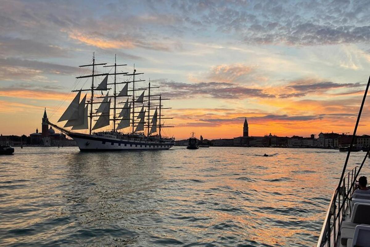 una grande barca a vela in acqua al tramonto