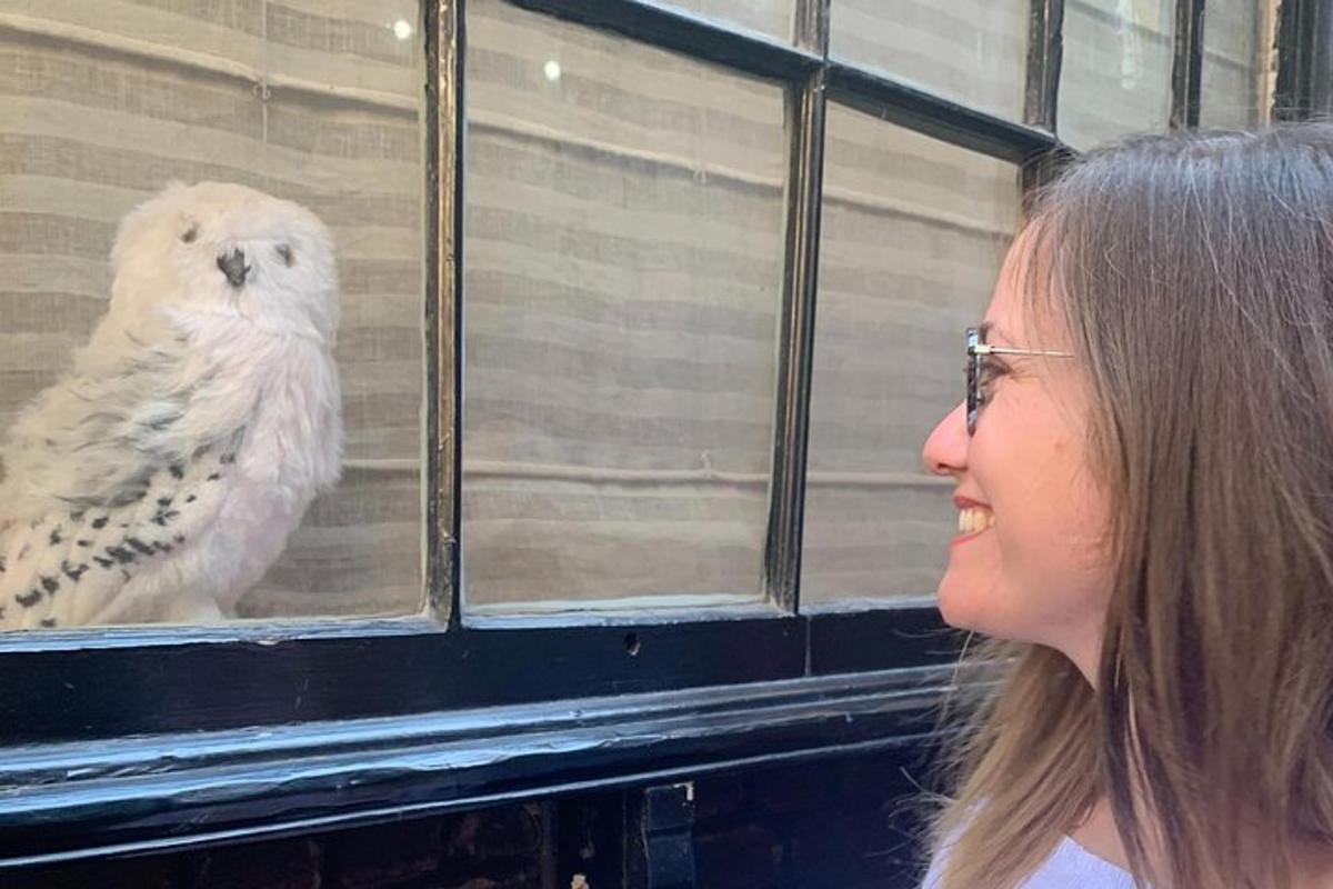 a woman is looking at a bird in a window