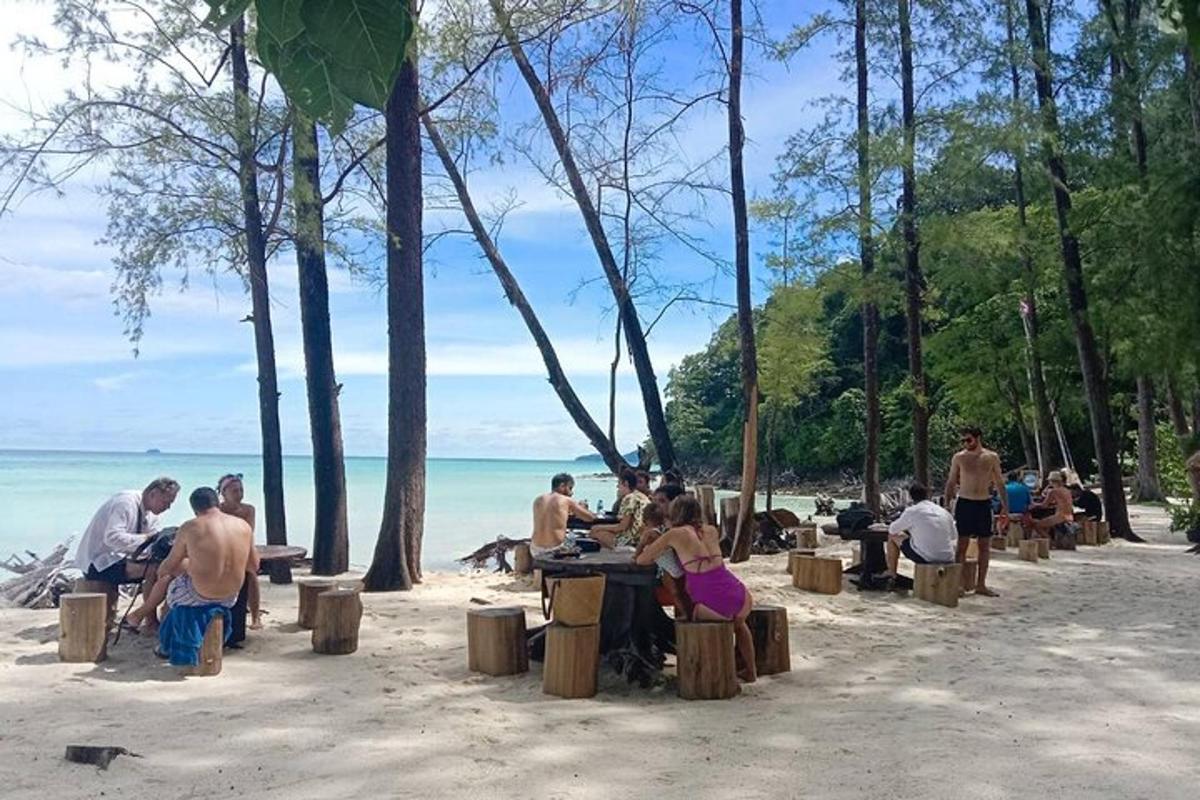 un gruppo di persone sedute ai tavoli sulla spiaggia