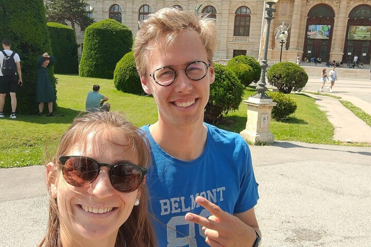 Strákur og stúlka standa fyrir framan byggingu
