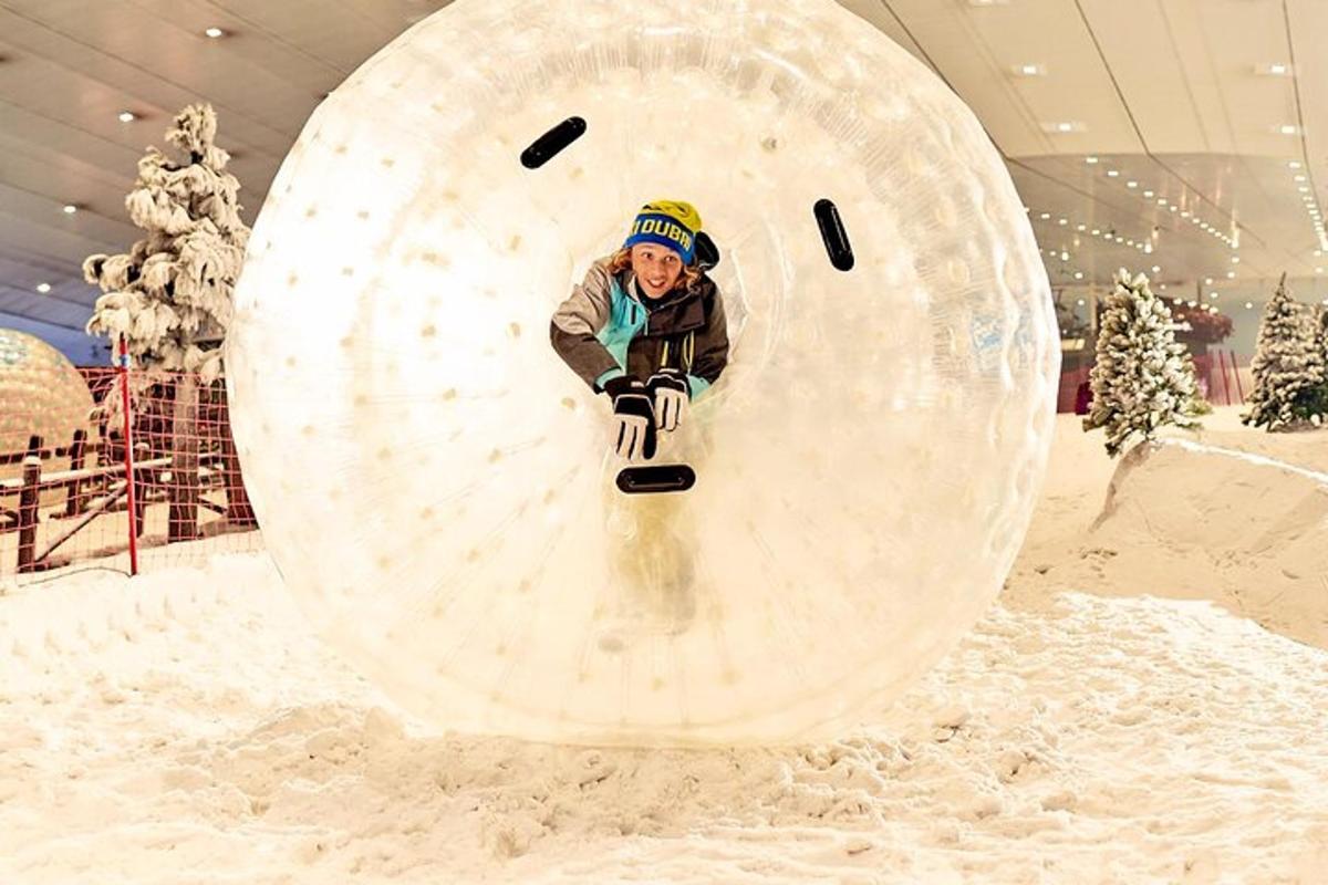 osoba jedoucí na snowboardu uvnitř sněhové koule