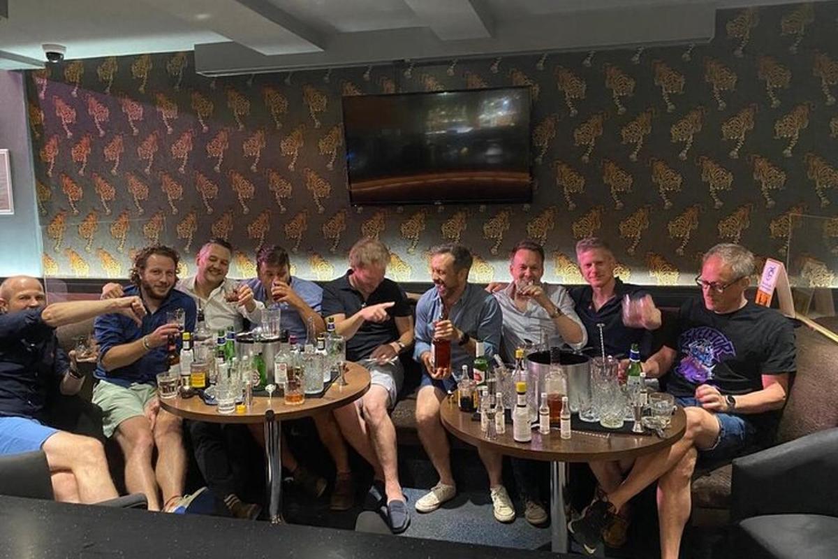 un gruppo di persone sedute su un divano a bere birra