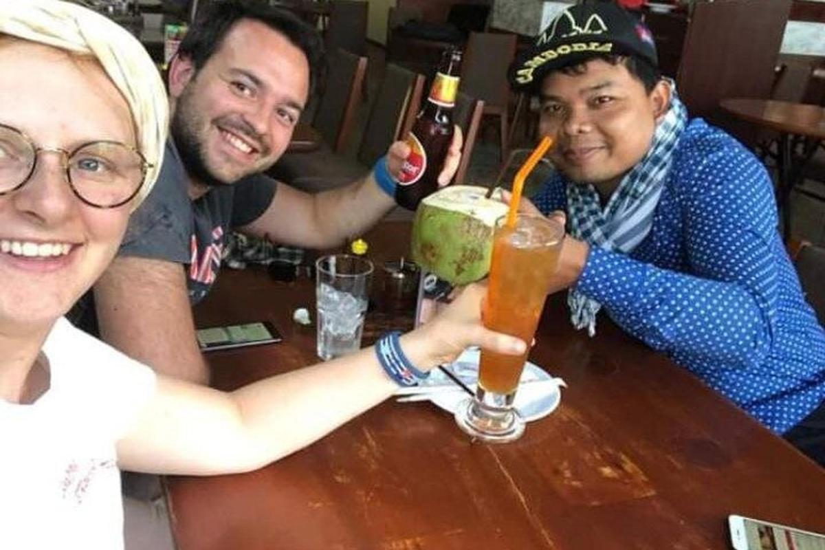 a group of people sitting at a table with a drink