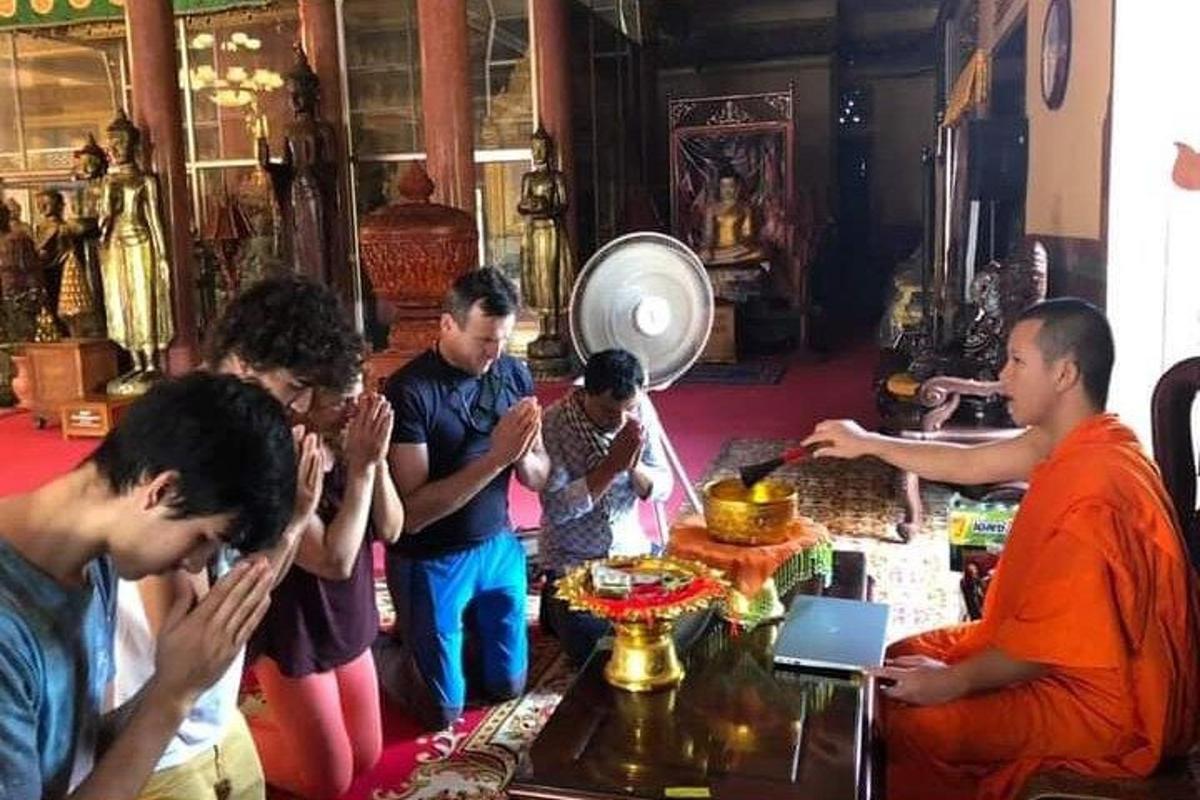 a group of people standing around a table in a temple