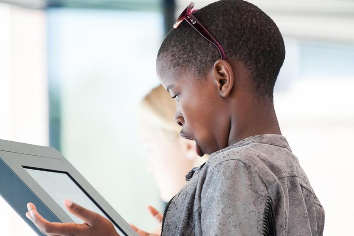 a young boy is looking at a tablet computer