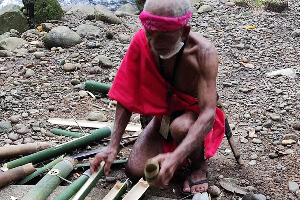 a man in a red dress playing with some sticks