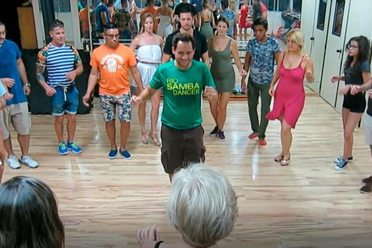 muškarac u zelenoj majici pleše u grupi ljudi