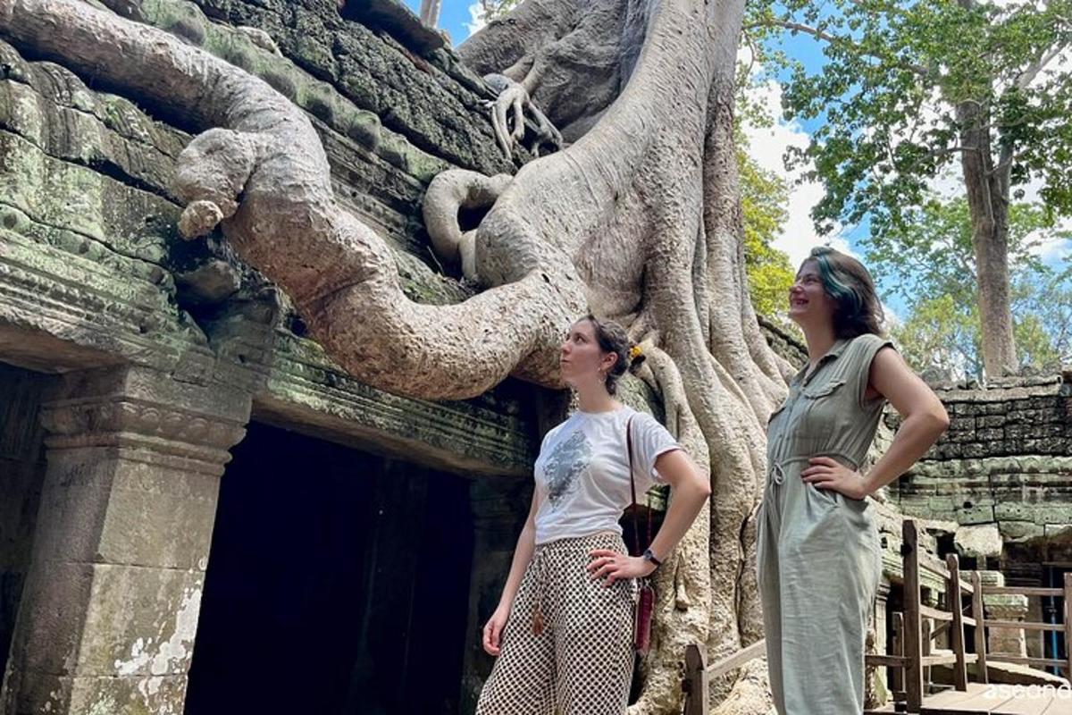 deux femmes debout devant un bâtiment avec un éléphant