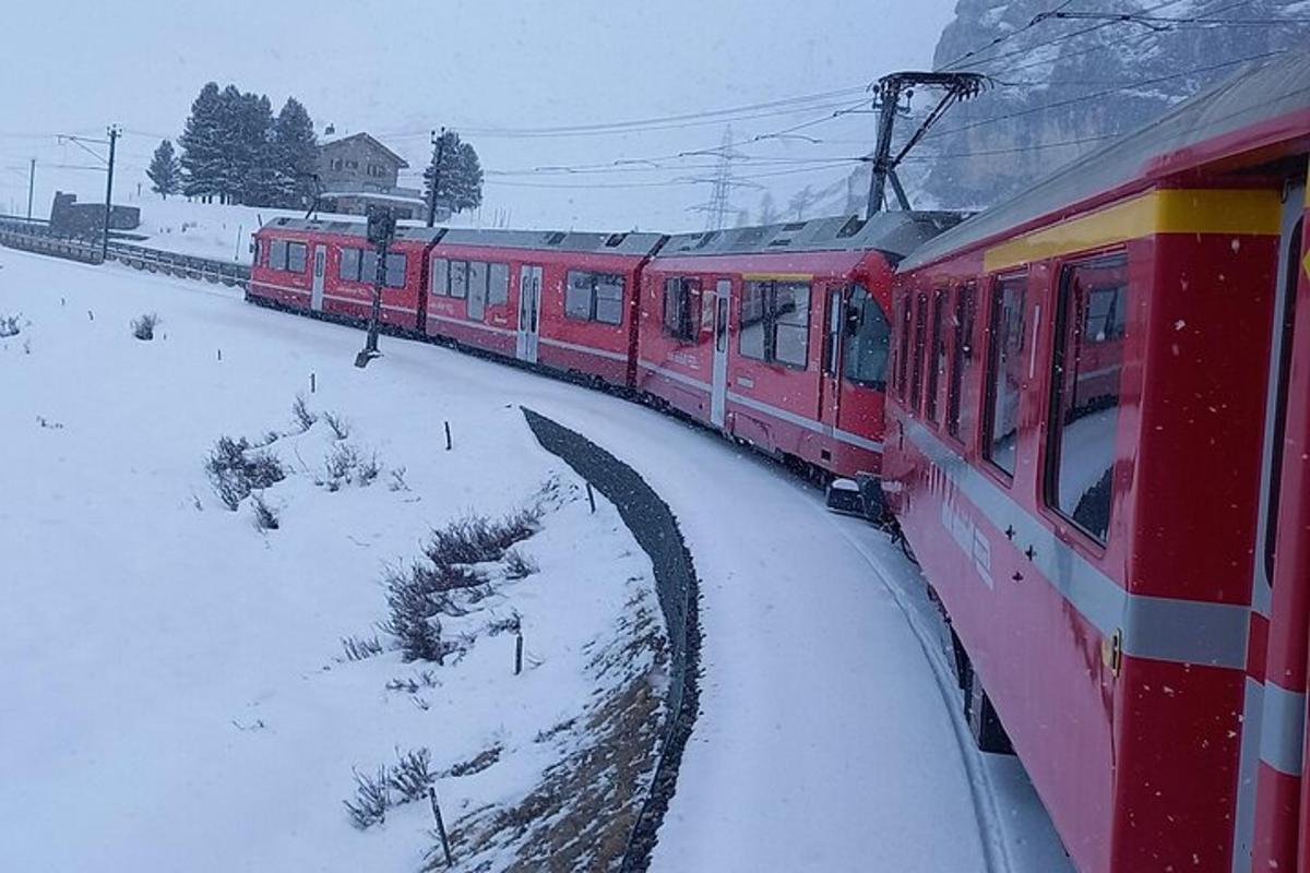 Un tren rojo en las vías en la nieve.