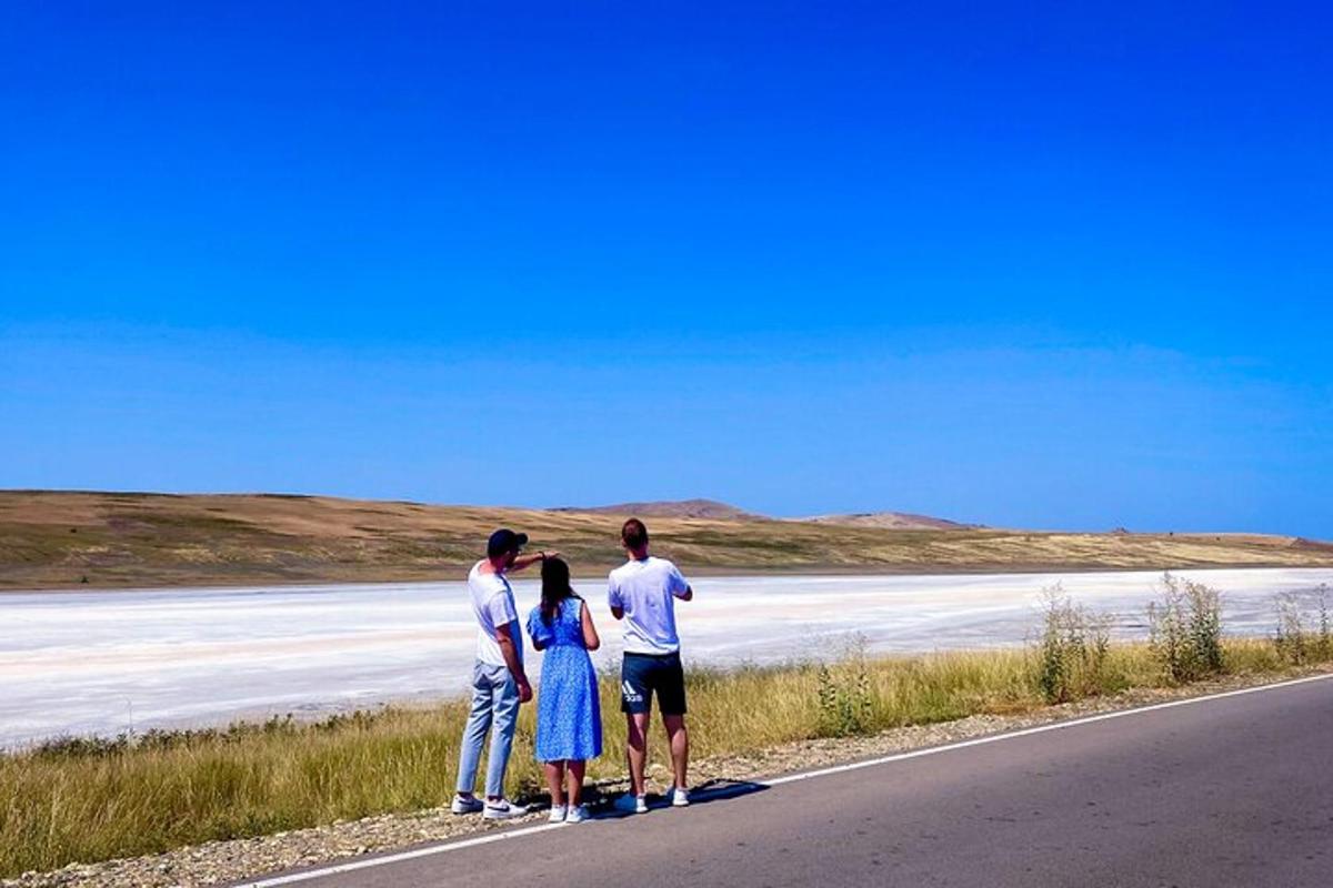 Un grupo de tres personas de pie al costado de una carretera.