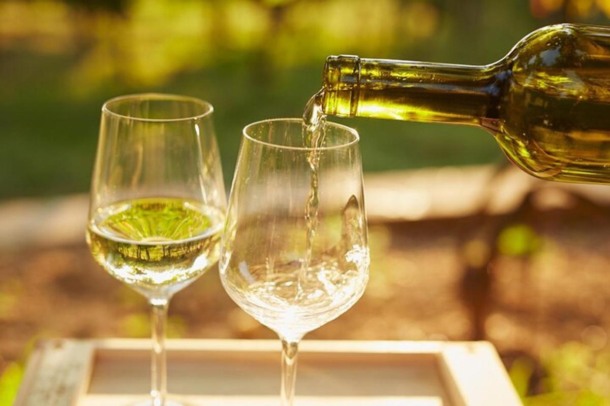 a bottle of wine being poured into two wine glasses