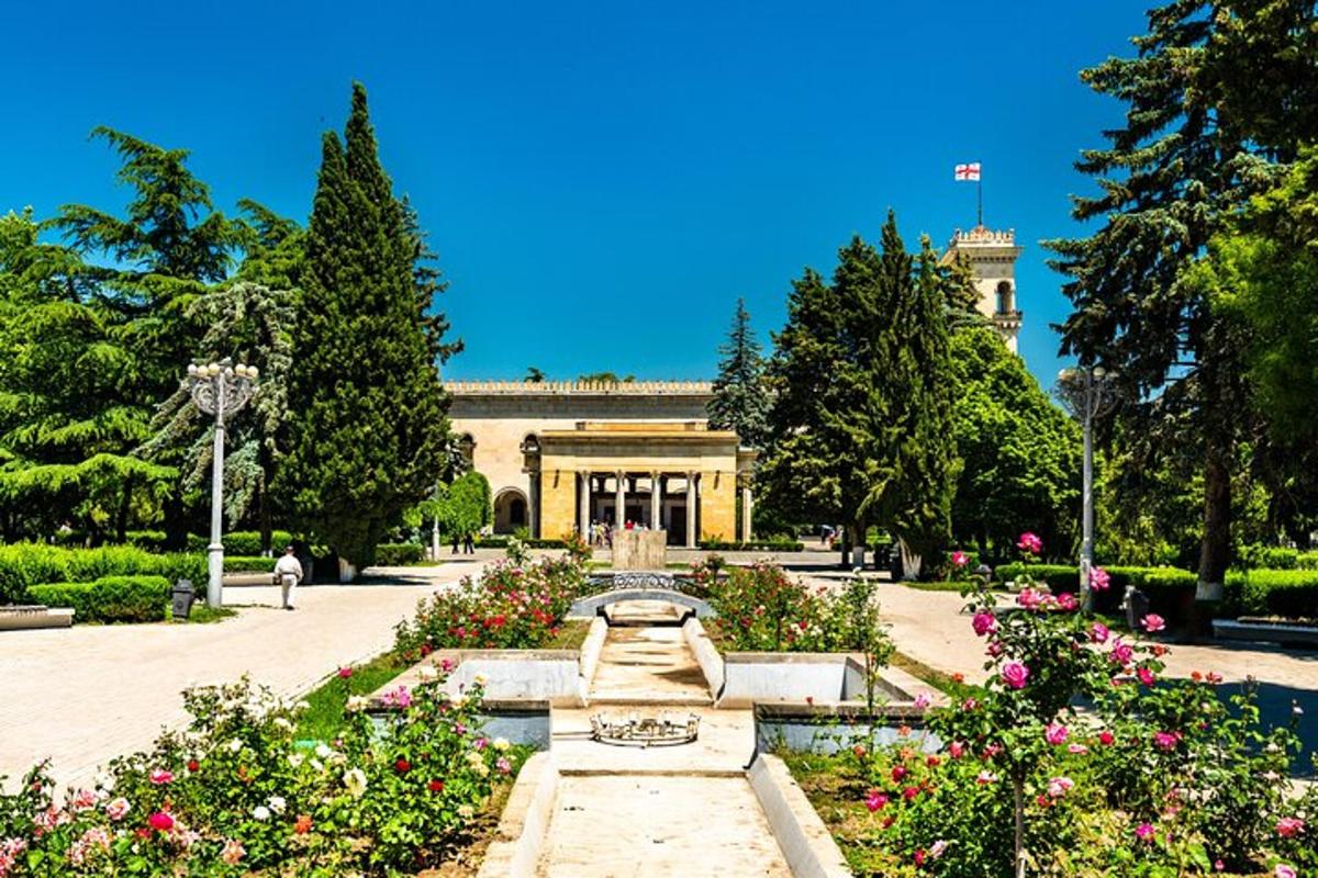 a garden with a fountain and flowers in front of a building