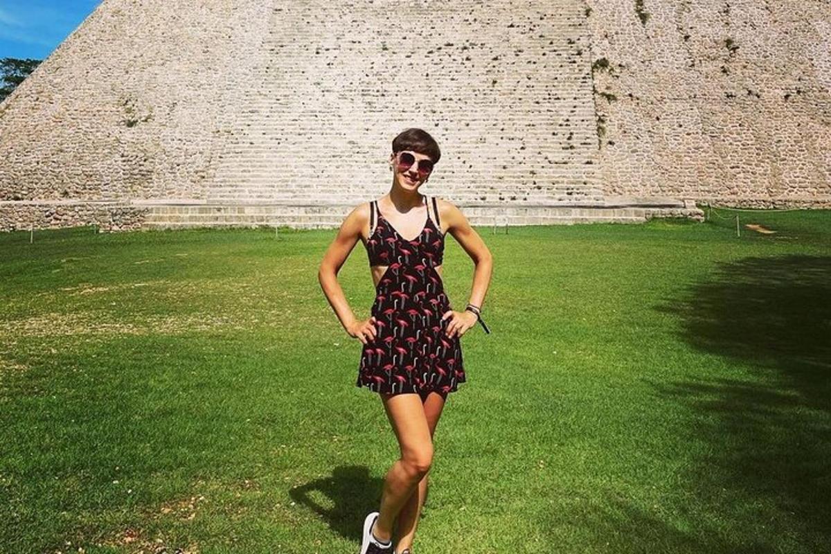 une femme en robe debout devant une pyramide