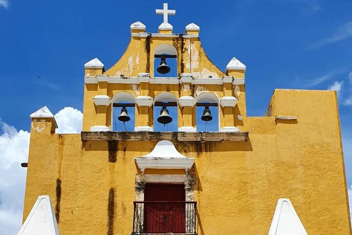 a yellow church with a cross on top of it