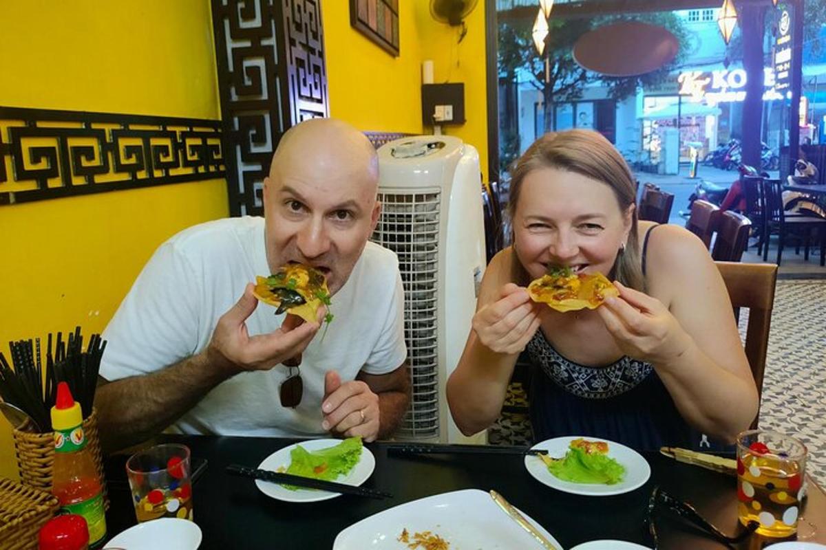 a man and a woman sitting at a table eating food