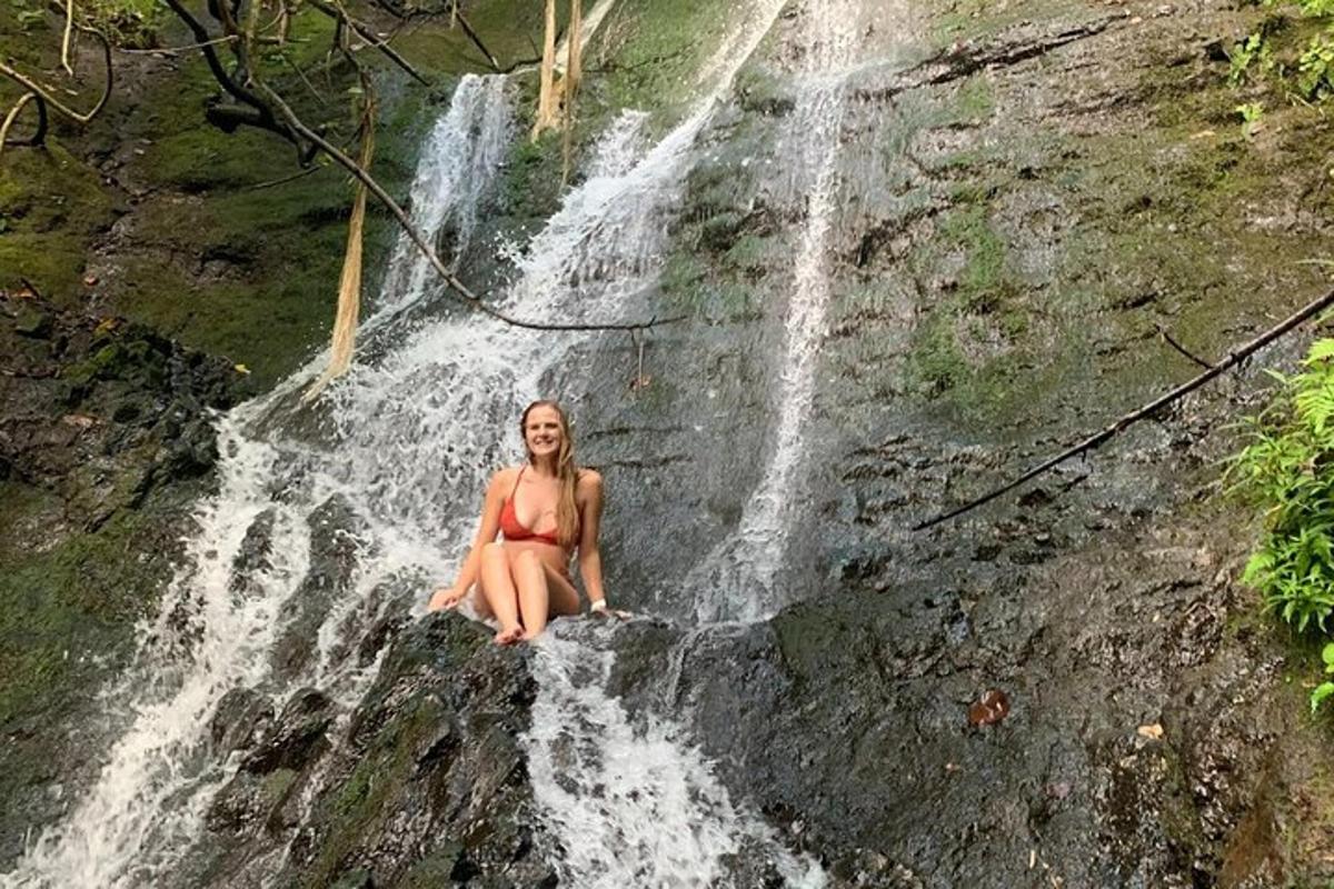o femeie în bikini stând pe o cascadă