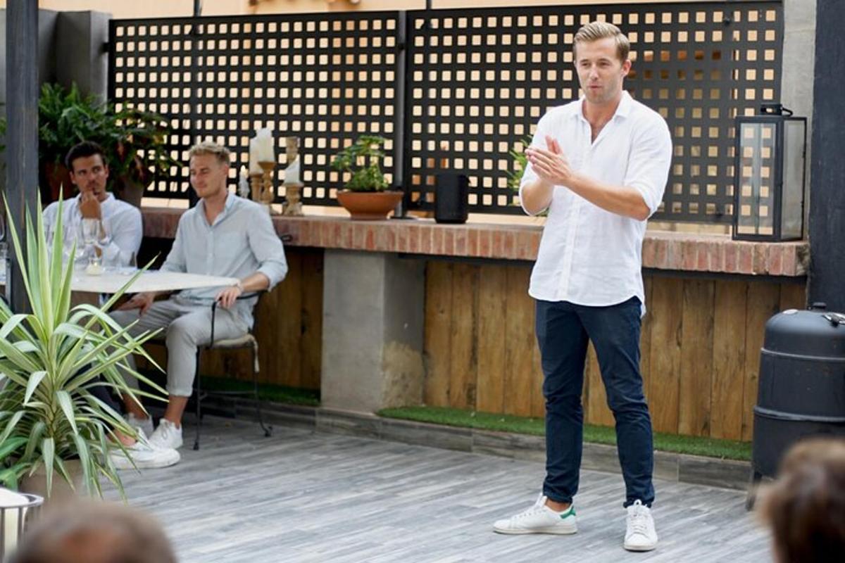 un uomo in piedi su un palco che parla a un gruppo di persone