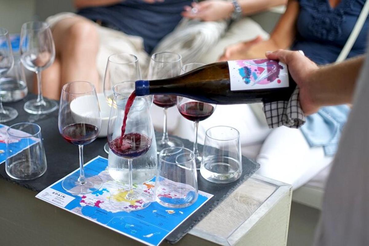 una persona che versa il vino nei bicchieri da vino su un tavolo