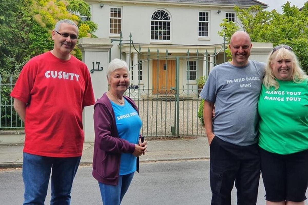 Un grupo de personas paradas frente a una casa