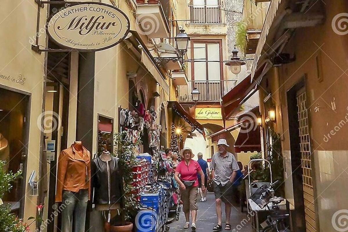 Un grupo de personas caminando por una calle estrecha en una ciudad.