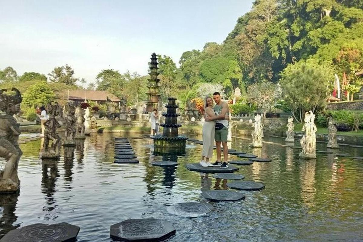 a man standing on a rock in a pond in a park